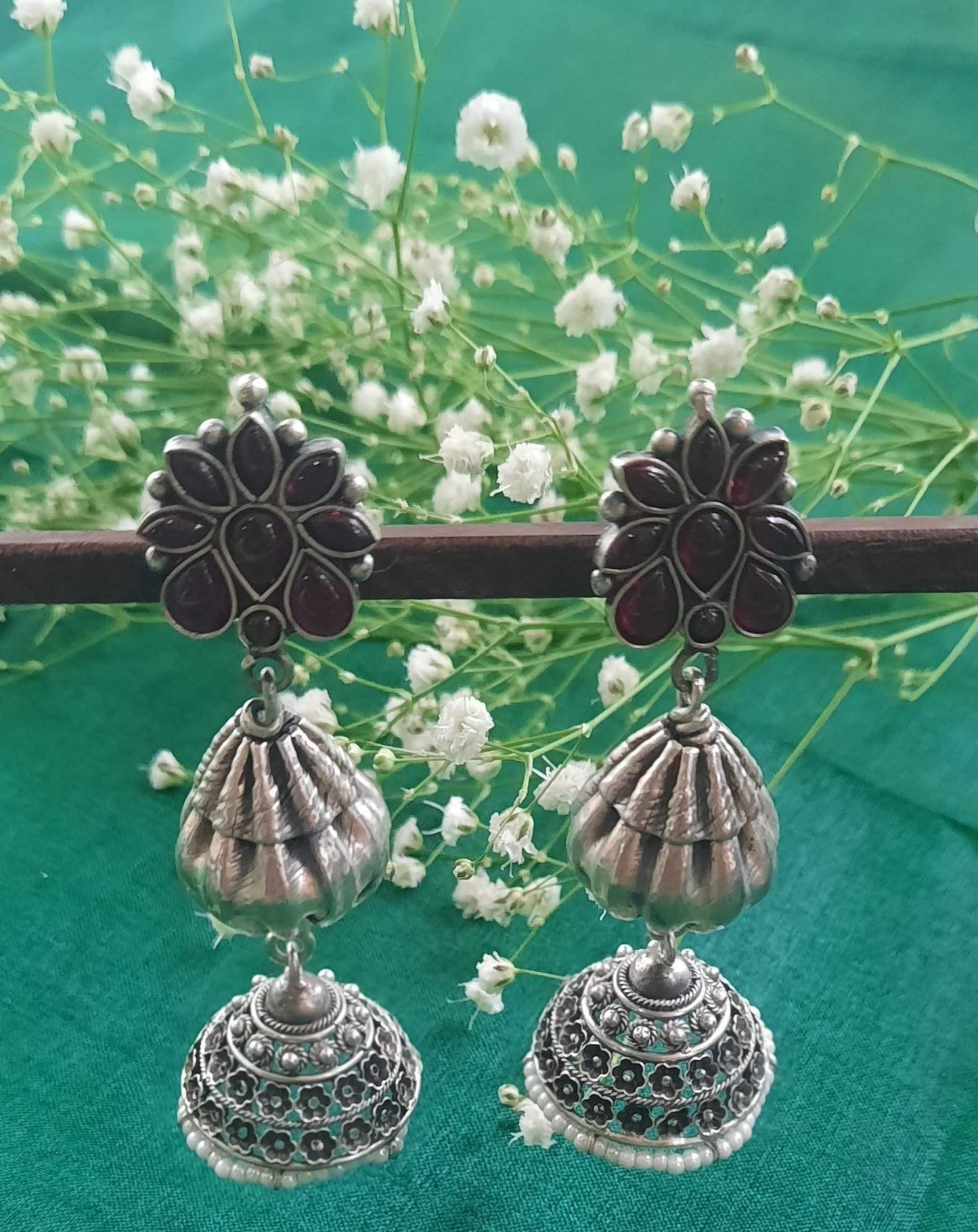 Close-up of Abha Kundan 2-Step Jhumka Earrings showcasing traditional floral-inspired work. The earrings feature a two-step design with intricate detailing and Kundan stone embellishments, capturing the essence of Indian heritage and elegance.